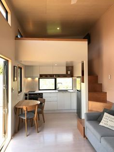 a living room filled with furniture next to a kitchen