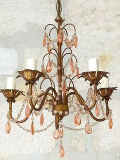 a chandelier hanging from the ceiling in a room with white walls and stone flooring