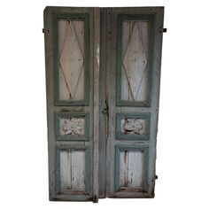 an old pair of wooden doors with carved designs on the front and side panels, both painted blue