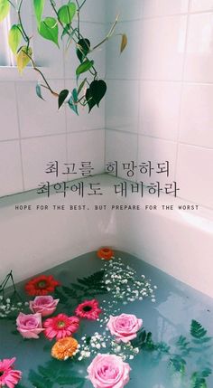 flowers are floating in a bathtub with water and leaves on the floor next to it