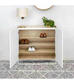 a white cabinet with shoes on it and a lamp