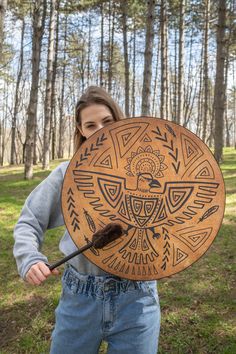 a woman holding a wooden shield with an arrow in it