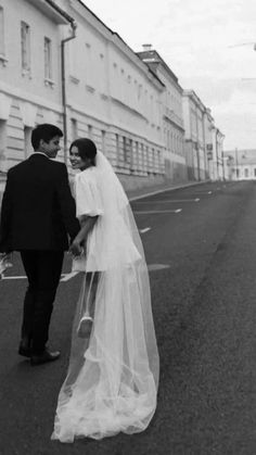 a bride and groom walking down the street