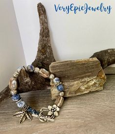 Rustic Beaded Gemstone Bracelet Handmade Ceramic Beads and Blue Sodalite Beads Artisan Boho Style Jewelry  A mottled blue and white sodalite gemstone bead along with handmade ceramic beads are the focal of this rustic artisan boho style bracelet. Sprinkled in are silver tone spacer beads in various shapes and sizes. A beautiful silver tone flower toggle clasp holds it closed.  As you may have noticed, I love dangles and this bracelet has three silver tone leaf charms to add more interest, balance and fun!    This statement bracelet will capture the eye - and imagination - everywhere you go; a Boho  treasure that was created by me, @VeryEpicJewelry!  Bracelet measures 8 1/2" long Bohemian Lapis Lazuli Beaded Bracelets, Adjustable Lapis Lazuli Beaded Bracelets Bohemian Style, Bohemian Beaded Bracelets With Lapis Lazuli Stones, Bohemian Lapis Lazuli Beaded Bracelets With Natural Stones, Bohemian Beaded Bracelets With Lapis Lazuli, Bohemian Lapis Lazuli Beaded Bracelets As Gift, Sodalite Round Beads Jewelry For Healing, Adjustable Sodalite Beaded Bracelets With Round Beads, Hand-strung Nature-inspired Beaded Bracelets