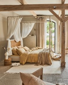 a large bed sitting under a wooden beam in a bedroom