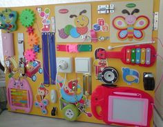 a child's play area with various toys and magnets on the back wall