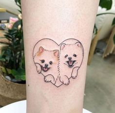 two pomeranian dogs in the shape of a heart tattoo on the left calf's leg