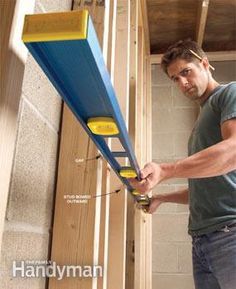 a man working on the side of a building with tools attached to it's sides