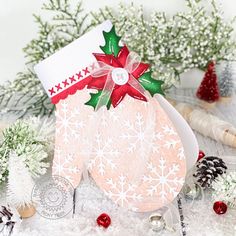 a christmas stocking sitting on top of snow next to pine cones and other decorations