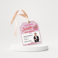 a pink gift tag with a woman's photo on it and a ribbon hanging from the top