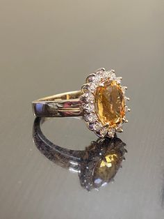 DeKara Designs Classic Metal- 14K Yellow Gold, .583. Stones- 1 Oval Imperial Topaz 3.50 Carats, 16 Round Diamonds G Color VS1 Clarity 0.55 Carats. Size- Choose Your Size, from 4-12. Please allow three to five working days for me to ship out your ring. I will start on making your ring as soon as transaction has been processed. Classic 14K yellow gold Art Deco influenced halo Imperial Topaz diamond engagement ring. The center stone is a whopping prong set 3.15 fiery oval shaped Peach colored beaut Oval Yellow Sapphire Diamond Ring Fine Jewelry, Yellow Sapphire Oval Diamond Ring, Wedding Topaz Ring With Baguette Cut, Dazzling Yellow Gold Sapphire Ring For Wedding, Baguette Cut Topaz Ring For Wedding, Luxury Gold Halo Ring With Accent Stones, Luxury Halo Setting Gemstones For Wedding, Cluster Diamond Gemstones For Wedding, Luxury Gemstones With Halo Setting For Wedding