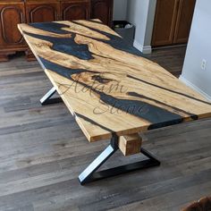 a wooden table with metal legs and black wood grain on the top, in a living room