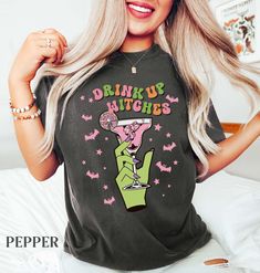 Is margarita or cocktails your "witches brew"? The "Drink Up Witches" shirt is perfect for anyone ready to brew up a good time at Halloween parties! Cheers, witches! ️🌙 I T E M * D E T A I L S Comfort Colors® SHIRTS are made with 6.1 oz/206 gsm 100% US-grown cotton jersey. The pigment-dyeing process gives the garment an authentic, lived-in character. Black and White shirts are direct-dyed. U N I S E X * S I Z I N G These shirts are unisex-sized. Please compare the measurements of your favorite Halloween Party Tops With Letter Print, Halloween Party Letter Print Tops, Halloween Party Graphic T-shirt, Brides Coven Shirts, Halloween Party Graphic Print T-shirt, Witch Bachelorette Party Shirts, Witch Graphic Tees, Witch’s Brew Cocktail, Cheers Witches