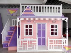 a pink and purple doll house with stairs