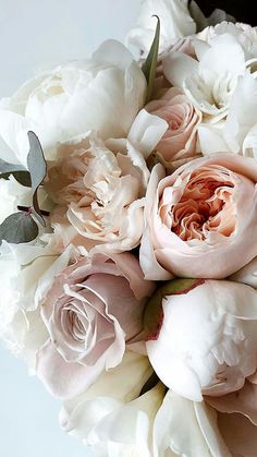 a bouquet of white and pink flowers sitting on top of a table