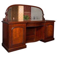 a wooden desk with mirror on top of it and an armoire in the middle