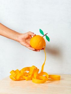 a person holding an orange and string attached to it