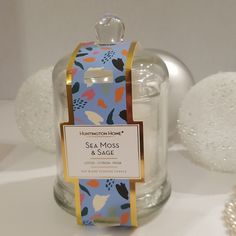 a sea moss and sage scented candle in a glass jar with a tag on it