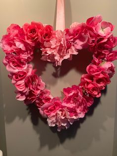 a heart shaped wreath made out of pink flowers