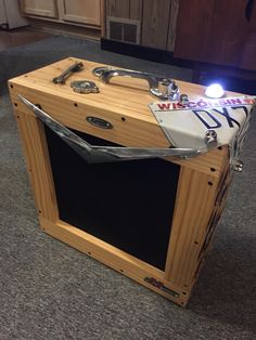 a wooden box that has some kind of light on it's side and is sitting on the floor