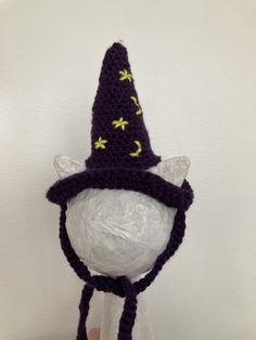 a crocheted hat with yellow stars on it and a purple knitted wizard's hat