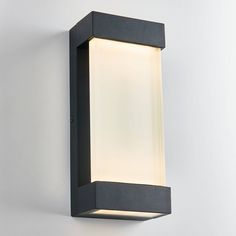 an outdoor wall light that is on the side of a white wall with a black frame