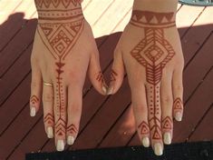 two hands with henna designs on them