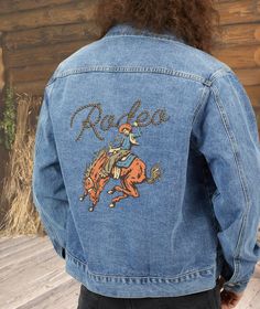 This is a great men's Rodeo jeans denim jacket. Your favorite barn coat, cotton denim jacket for cool mornings and evenings. This Western style painting of a retro poster style design is so unique and the perfect gift for a hard-to-buy Dad, rancher or husband. The ability to print on denim is brand new so you will not find anything like right now. So unusual, so great, and so YOU! I am so excited to be able to print my artwork and designs on this new jacket medium. Here are my custom-printed den Western Blue Denim Jacket For Fall, Western Style Cotton Outerwear In Medium Wash, Western Style Medium Wash Denim Jacket With Pockets, Western Style Denim Blue Jacket For Fall, Western Style Medium Wash Outerwear For Spring, Western Style Cotton Denim Jacket For Fall, Western Style Medium Wash Cotton Outerwear, Western Style Cotton Denim Jacket In Medium Wash, Casual Cotton Denim Jacket For Rodeo