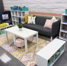 a living room filled with furniture and bookshelves next to a wall mounted bookcase