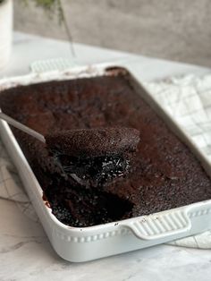 a piece of chocolate cake in a white dish