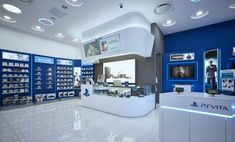 the inside of a store with blue walls and white tile flooring is lit by recessed lights