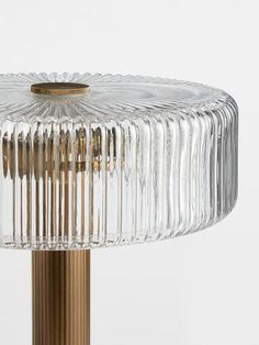 a glass table lamp with a brass base and clear, ribbed lampshade