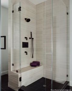 a walk in shower sitting next to a glass wall