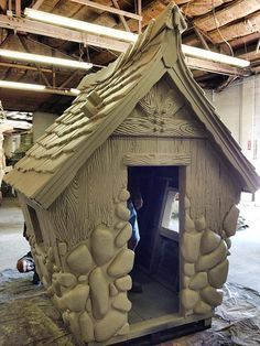 a man is making a house out of clay