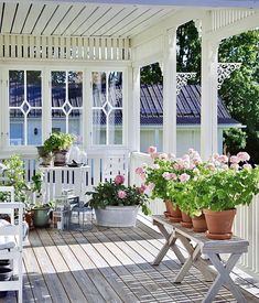 a white porch with potted plants on it