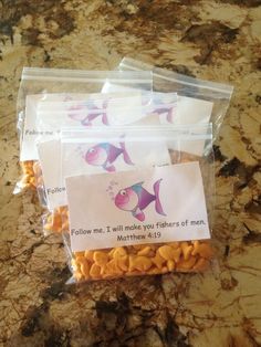 three bags filled with fish treats on top of a counter