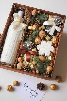 a wooden box filled with assorted holiday treats and decorations next to a note card