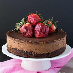 a chocolate cake with three strawberries on top