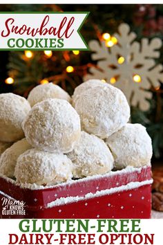 a red box filled with powdered sugar covered donuts next to a christmas tree