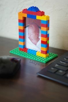 a lego photo frame sitting on top of a desk next to a computer mouse and keyboard