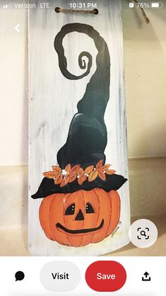 a wooden sign with a cat wearing a witches hat and pumpkins on it's head