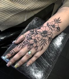 a woman's hand with flowers on it