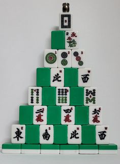 a green and white christmas tree made out of domino tiles with chinese characters on it