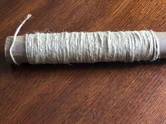 a spool of twine sitting on top of a wooden table