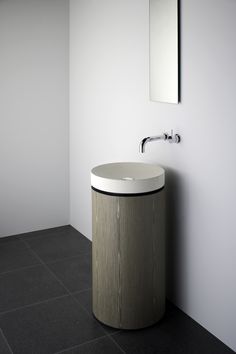 a white sink sitting under a mirror next to a wall