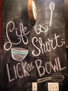 a chalk board with the words life is short lick the bowl written on it