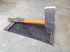 an orange and black shovel sitting on top of a cement floor