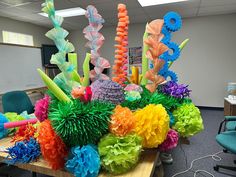 an office cubicle decorated with colorful paper flowers and giant balls in the shape of seahorses