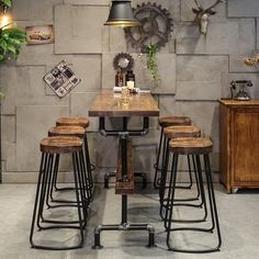 a table with four stools in front of a brick wall and deer heads on the wall