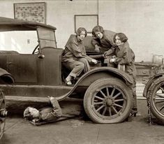 three women sitting on the back of an old truck